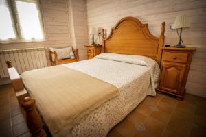 Un dormitorio con una gran cama de madera y una ventana en Apartamentos Pumarin, en Santa Marina