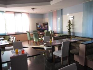 um restaurante com mesas e cadeiras e uma televisão em Hotel Green castellani em Vicenza