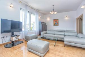 a living room with a couch and a flat screen tv at VILLA ALEXANDRA in Kumbor