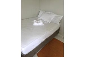 a bed with white sheets and pillows on it at Kitnet na Boa Vista, Recife - 1203 in Recife