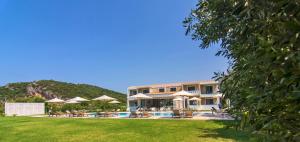 ein Resort mit Pool, Liegestühlen und Sonnenschirmen in der Unterkunft Olivista Hotel in Perdika