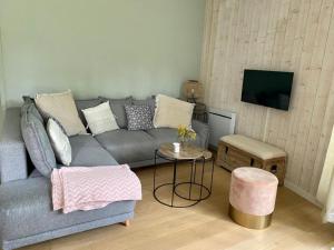 a living room with a gray couch and a table at Appartement cosy village de L'Herbe in Lège-Cap-Ferret