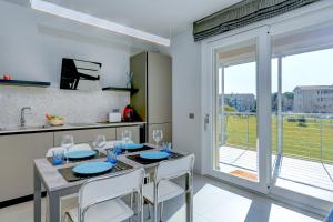 een keuken met een tafel met stoelen en een groot raam bij Rio Beach Apartment in Desenzano del Garda