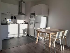 eine Küche mit einem Holztisch und weißen Geräten in der Unterkunft Appartement haussmannien au bord du lac panorama in Clamart