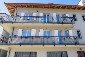 un edificio con puertas azules y balcones en Appartamenti Rocca - CAV La Casa di Rosa, en Monforte dʼAlba