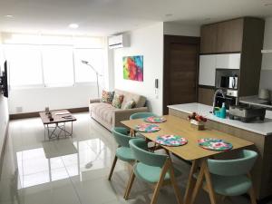 a kitchen and a living room with a table and chairs at Departamento La Boutique in Santa Cruz de la Sierra