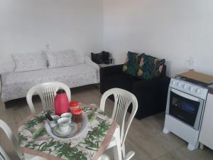 Una sala de estar con una mesa y sillas y un sofá. en H&C Pousada Ap, en São Gabriel 6 fotos más