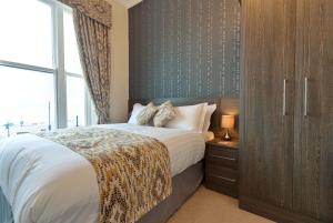 a bedroom with a bed and a large window at Lauriston & Lawton Court Hotel in Llandudno