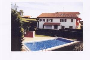 una piscina frente a una casa blanca en GUETHARY APPARTEMENT PLAIN PIED PROCHE PLAGE CENITZ en Guéthary
