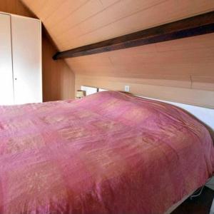 a bed with a pink blanket on top of it at Huis Den Keibilk in Heuvelland