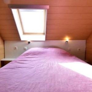a bedroom with a purple bed with a window at Huis Den Keibilk in Heuvelland