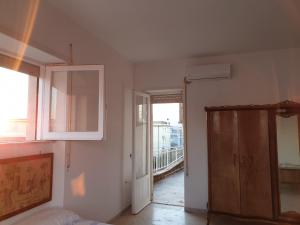 ミントゥルノにあるvacanze al mareのベッド1台、キャビネット、窓が備わる客室です。