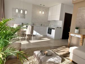 cocina y sala de estar con armarios blancos en Panoráma apartman, en Alsóörs