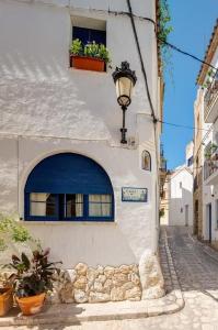 un edificio bianco con una porta blu e una finestra di La Casita - centro histórico y playa a Sitges
