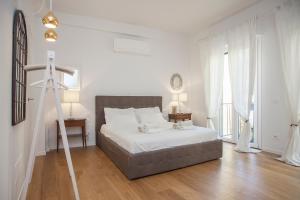 Un dormitorio blanco con una cama y una escalera. en LoveTheStylish OldBridge - LoveTheApartments, en Florencia