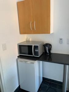a microwave sitting on top of a counter in a kitchen at Lemon Tree Guest Cottage in Featherbrooke Estate in Krugersdorp +3 photos