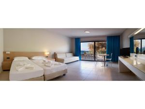a hotel room with two beds and a balcony at Nautilus Bay Hotel in Kissamos +37 photos