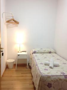 1 dormitorio con 1 cama y 1 mesa con lámpara en Hostal Nersan2, en Madrid
