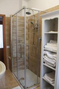 un bagno con doccia e asciugamani di La Casa di Sandra a Porto Potenza Picena