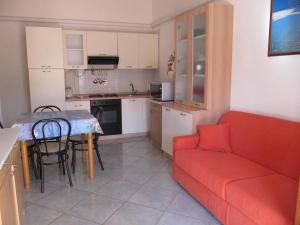 a living room with a red couch and a table at Casa Relax in Villasimius