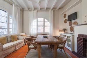 un soggiorno con tavolo e divano di La Casita - centro histórico y playa a Sitges
