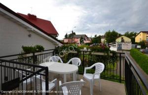 a white table and chairs on a balcony at Pokoje goscinne DW Antom in Dźwirzyno