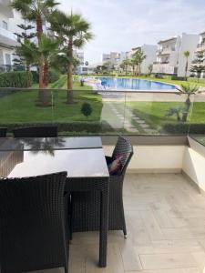 una mesa y sillas con vistas a la piscina en Blanca Beach, en Sidi Rahal