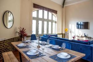 uma sala de jantar com uma mesa e um sofá azul em Post Office Penthouse em Great Yarmouth