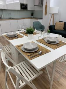 uma mesa de jantar branca com pratos e copos em TeruelHOME II em Teruel