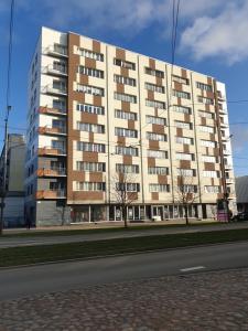 a large white building with trees in front of it at Rose apartaments in Liepāja