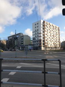 an empty city street with a tall white building at Rose apartaments in Liepāja