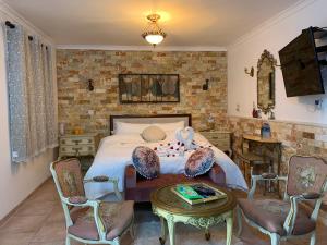 Schlafzimmer mit einem Bett mit Stühlen und einem Tisch in der Unterkunft farmer’s suite room in Bat Shelomo