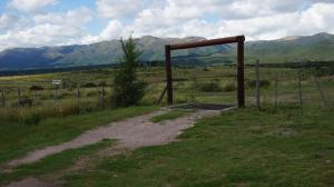 拉库布蕾Los Chañaritos的一条土路,在有栅栏和山 ⁇ 的田野里