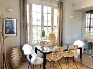 a dining room with a glass table and chairs at Historic "Touquettoise" villa, located in heart of the village, 100m from the beach, with sunny terrace and private garden in Le Touquet-Paris-Plage