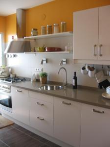 a kitchen with white cabinets and a sink at 1ª LINEA DE MAR CON VISTA FANTÁSTICA in L'Ampolla