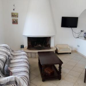 ein Wohnzimmer mit einem Sofa und einem Kamin in der Unterkunft Casa in campagna in San Giovanni Suergiu
