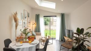 a living room with a table and a tv at Le Nid Douillet : Superbe Appartement + Jardin privatif in Rouen