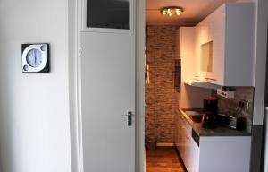 una cocina con armarios blancos y un reloj en la pared en Ferienwohnung Sonnenblick en Altenau