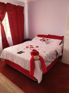 a bedroom with a bed with red and white sheets at Naomi's Place in Johannesburg