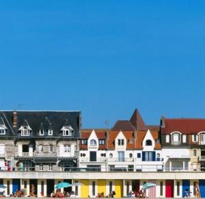 a group of buildings with people on the beach at Historic "Touquettoise" villa, located in heart of the village, 100m from the beach, with sunny terrace and private garden in Le Touquet-Paris-Plage