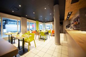 a restaurant with tables and chairs and a counter at ibis budget Flensburg Handewitt in Handewitt