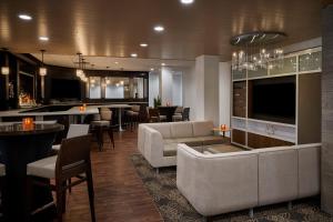 a living room with a couch and a bar at Holiday Inn Alexandria at Carlyle, an IHG Hotel in Alexandria
