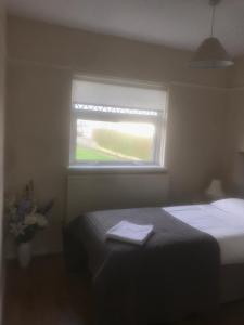 a small bedroom with a bed and a window at 'Y Brynteg' Nr Porthcawl Holiday Home in Pyle