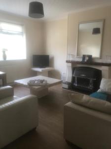 a living room with a couch and a table at 'Y Brynteg' Nr Porthcawl Holiday Home in Pyle