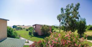 een uitzicht op een tuin met een huis en bloemen bij Résidence Marina di Capitello in Porticcio