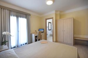 a bedroom with a bed and a window at Hotel Belvir in Villasimius