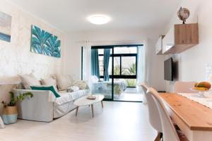 Sala de estar blanca con sofá y mesa en Luxury Sea Apartment Lanzarote PaLù Holiday House, en Costa Teguise