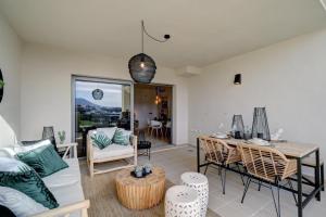 ein Wohnzimmer mit einem Sofa, einem Tisch und Stühlen in der Unterkunft Boho Style Flat- Acosta in Estepona