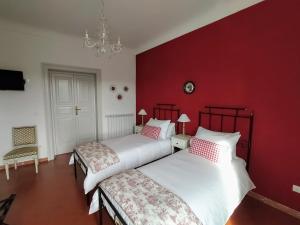 two beds in a room with red walls at Casa Borrelli in Casoli