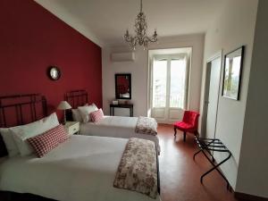 a bedroom with two beds and a red wall at Casa Borrelli in Casoli